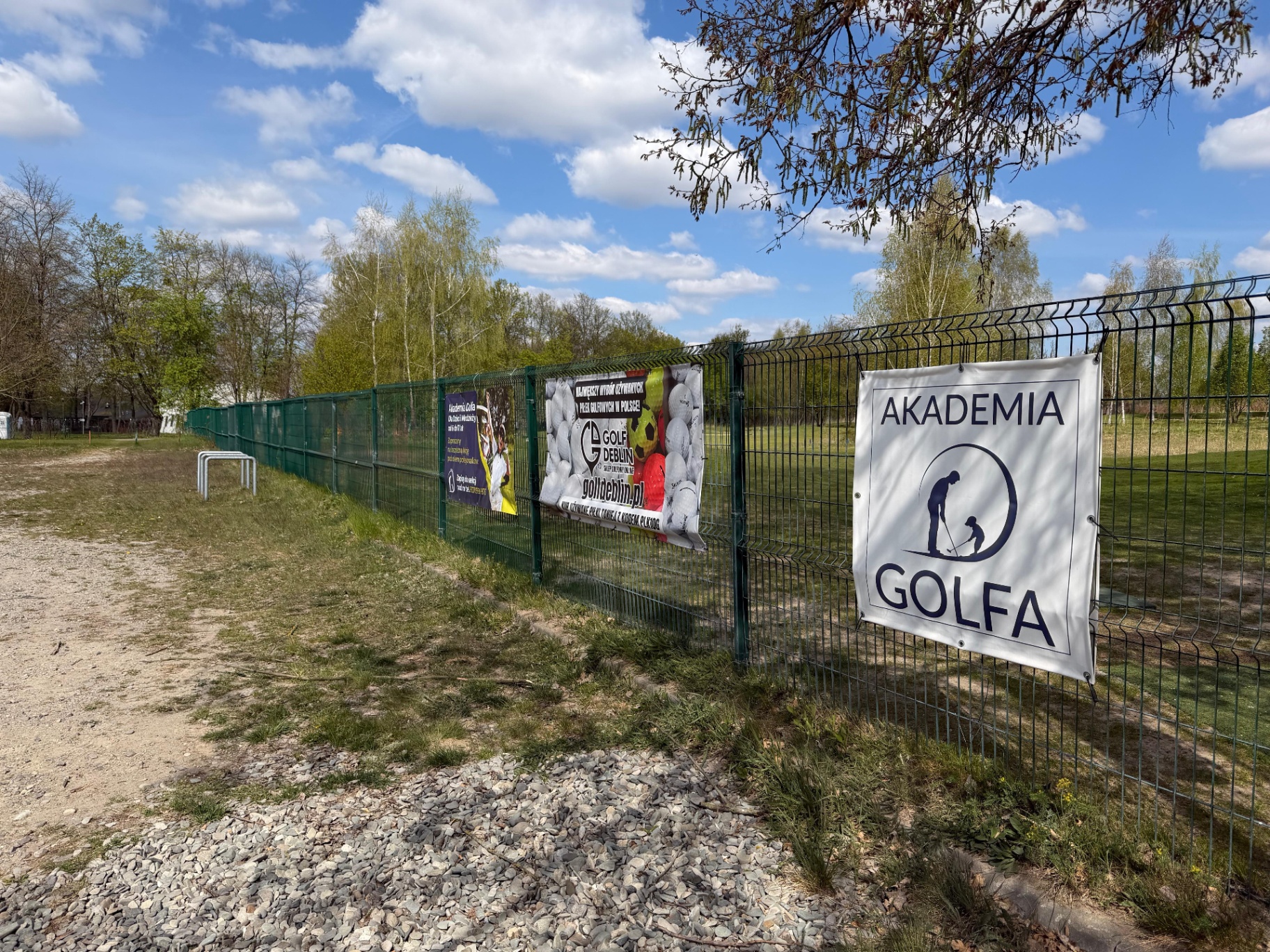 Ogrodzenie Akademii Golfa w Lublinie z przykładowymi banerami reklamowymi i dobrym dojazdem.